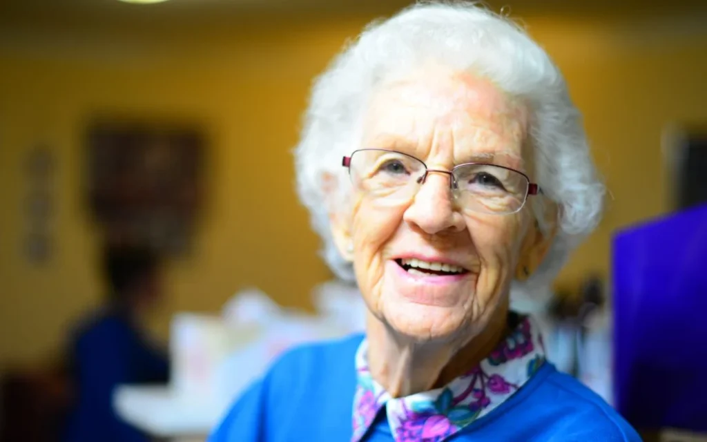 An elderly woman smiling.
