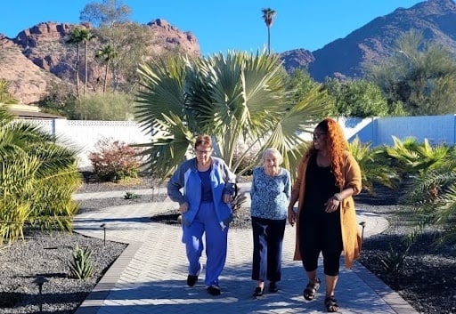 A resident staff giving a tour of the residence toc a woman and her elderly mother