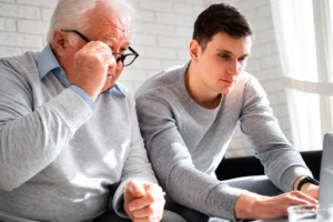 Older man and younger family member discussing senior care